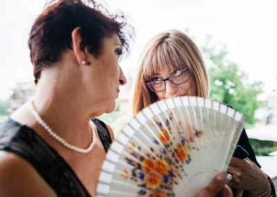 Groom's mother talking with a friend, documentary wedding photography