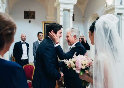 Lo sposo guarda il papà la sposa durante il matrimonio nella chiesa di Santa Prisca