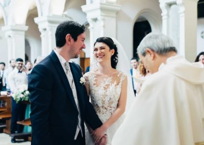 Gli sposi sorridono nella chiesa di Santa Prisca durante il matrimonio