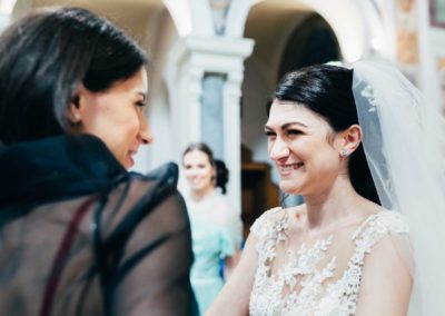 La sposa sorride ad un'invitata nella chiesa di Santa Prisca alla fine del matrimonio