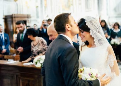 Bacio degli sposi all'entrata della chiesa di Santa Maria di Loreto a Roma durante un matrimonio