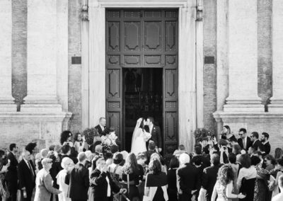 Bacio degli sposi all'uscita della chiesa di Santa Maria di Loreto a Roma durante un matrimonio