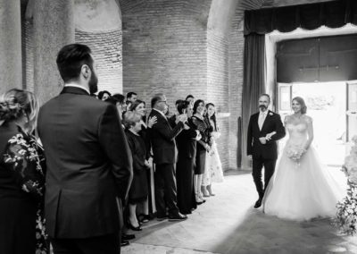 La sposa guarda lo sposo mentre entra con il padre per la cerimonia del Matrimonio nel Mausoleo di Santa Costanza a Roma