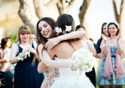 La sposa abbraccia l'amica con il bouquet a Tenuta Tor de Sordi durante un Matrimonio